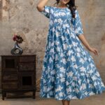 Woman wearing western cotton dress with floral design, standing in front of boutique showroom