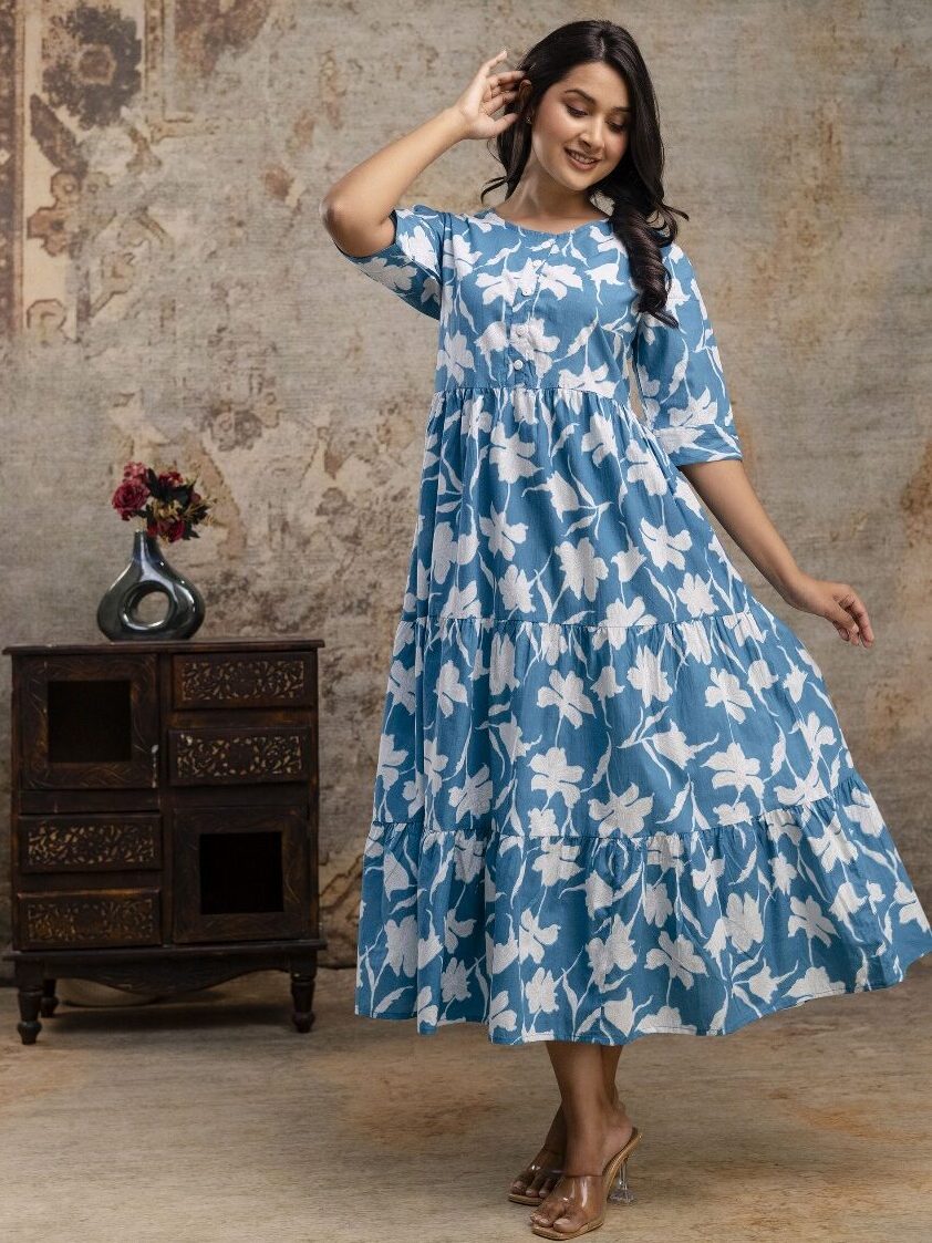 Woman wearing western cotton dress with floral design, standing in front of boutique showroom