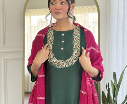 Young woman exploring fashion through ethnic wear, wearing an elegant dark green kurti with detailed neckline embroidery and a deep pink dupatta, styled with statement earrings.