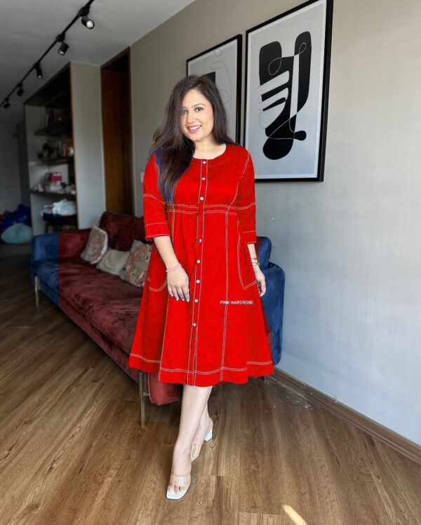 Woman wearing a red cotton slub short dress with front buttons and white stitch accents