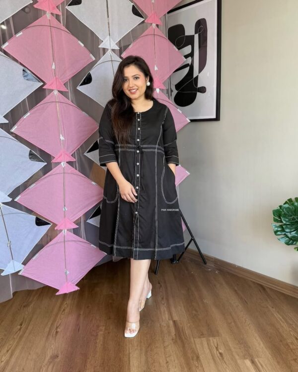 Woman wearing a black cotton slub short dress with white stitch detailing